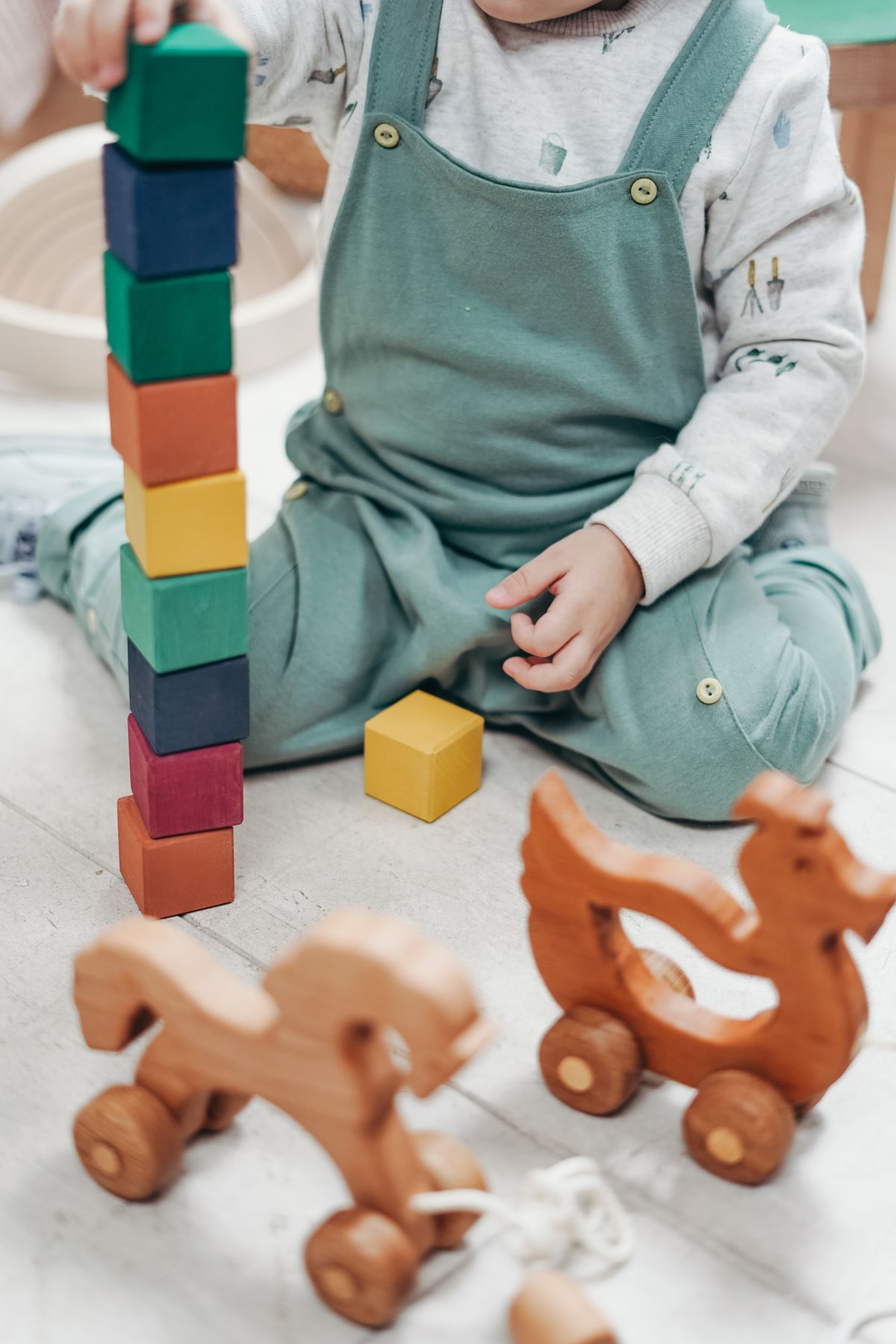 A child carefully stacking colorful blocks into a tower