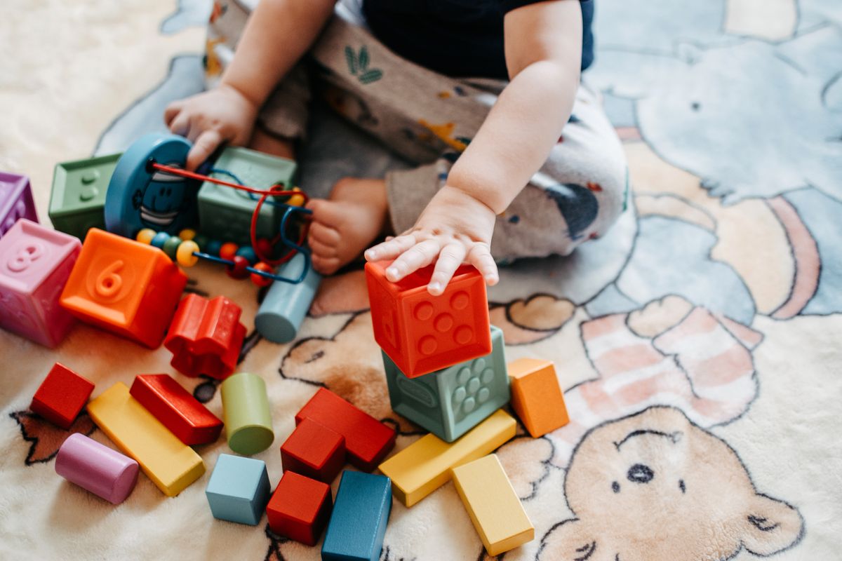A young child playing with colorful learning blocks